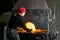 Female metal artist pulls a workpiece from a blacksmith`s furnace with pincers