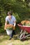 Female middle age gardener planting mums in yard