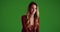 Female millennial sitting in contrasty lighting on green screen