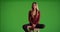 Female millennial sitting looking at the camera on green screen