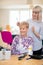 Female Mobile Hairdresser Cutting Senior Womans Hair At Home
