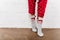 Female model in red cute night pants standing on top-toes. Indoor close-up photo of lady in gray socks..