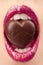 Female mouth with chocolate candy