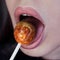 Female mouth with lollipop candy looks like a planet Venus