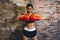 Female muscular sport boxer with boxing gloves posing over wall