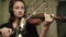 Female musician with headphones rehearsing the instrumental melody with violin