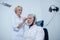 Female neurologist adjusting electrode cap on gray-haired male patient head