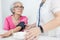 Female nurse checking blood pressure of a senior woman at home,Home carer checking patients blood pressure