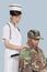 Female nurse comforting disabled US Marine Corps soldier in wheelchair over light blue background