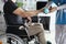 Female nurse helps lift dumbbell to disabled patient rehabilitation therapy