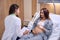 Female nurse writing examination results of pregnant woman before childbirth