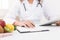 Female nutritionist counting calories in hospital, closeup