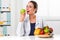 Female nutritionist eating a Green Apple in her office