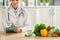 Female nutritionist sitting at table with vegetables and glass of milk in her office