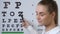 Female oculist pointing letter test chart, eyesight examination, vision checkup