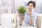 Female office worker holding potted plant