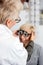 Female ophthalmologist examining mature woman at the ophthalmology clinic, determining diopter