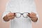 Female ophthalmologist with eyeglasses on light background