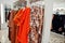 Female orange colorful clothing set of on the racks in clothing store brand new modern boutique. Spring summer dress collections