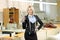 Female owner of a business standing inside a textile factory holding a scissors