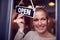 Female Owner Of Small Business Turning Round Open Sign On Shop Door