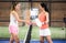 Female paddle tennis players shaking hands at end of match
