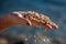 Female palm holding handful of a small pebble stones, some pebbles are falling