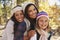 Female parents and daughter in a forest looking to camera