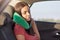 Female passenger sleeps in car while rides on long distance, uses small pillow as has pain in neck, takes nap, has rest, feels tir