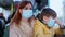 Female passenger together with son take precautions in public place and wear medical mask to protect against viruses and