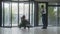 Female patient with disability rides in clinic through revolving doors