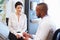 Female Patient And Doctor Have Consultation In Hospital Room