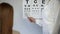 Female patient reading during eyesight examination clinic, visit ophthalmologist