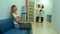 Female patient waiting in hospital hall while two doctors consulting