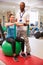 Female Patient Working With Physiotherapist In Hospital