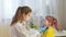 Female pediatrician doctor examines a little girl. A nurse examines a child\'s throat in a private clinic. doctor