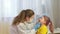 Female pediatrician doctor examines a little girl. A nurse examines a child\'s throat in a private clinic. Doctor