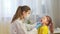 Female pediatrician doctor examines a little girl. A nurse examines a child\'s throat in a private clinic. doctor