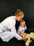 Female pediatrician playing with boy listening teddy bear by stethoscope
