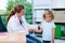 Female pediatrician in white lab coat examined little patient