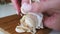 Female peeling garlic cloves on a wooden cutting board for immunity. Close up