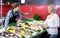 Female pensioner purchasing chilled on ice fish