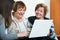 Female pensioners and relative browsing web on laptop