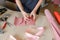 Female person creating pink leather handmade wallet at home.