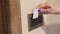 Female person hand puts back key card into room card holder