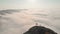 Female person silhouette standing above clouds on viewpoint of beautiful panorama