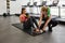 Female Personal trainer assisting woman, weighted ball sit up crunches