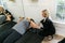 A female personal trainer helping a client exercise, train, and build muscle using small hand weights in a gym