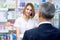 Female pharmacist consulting customer in drugstore.