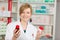 Female Pharmacist Holding Pill Bottles In Pharmacy